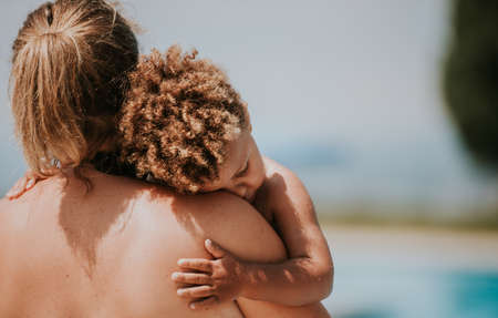 Cute toddler boy fell asleep in mothers armsの写真素材