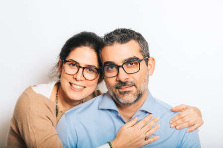 Studio portrait of happy couple wearing eyeglasses, posing together on white backgroundの写真素材