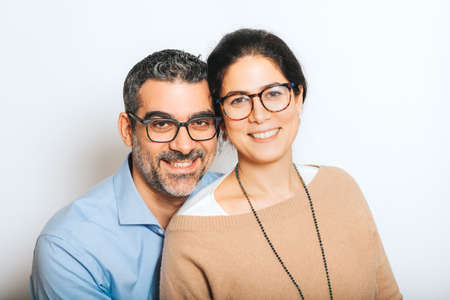 Studio portrait of happy couple wearing eyeglasses, posing together on white backgroundの写真素材