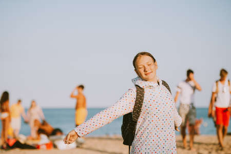 Outdoor portrait of happy teenage girl leaving the beach in the end of the day, summer family...