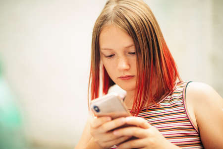 Close up portrait of young teenage girl using smart phoneの写真素材