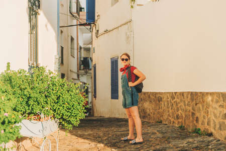 Funny teenage girl traveler walking on the streets of Costa Brava, wearing backpack. Travel with kids family vacation on south of Spain, image taken in Cadaquesの写真素材