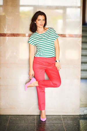 Fashion portrait of beautiful woman wearing bright pink trousers and high heel shoesの写真素材