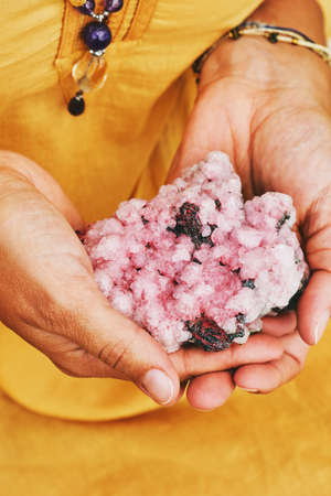 Close up image of pink amethyst crystal holding by a womanの写真素材