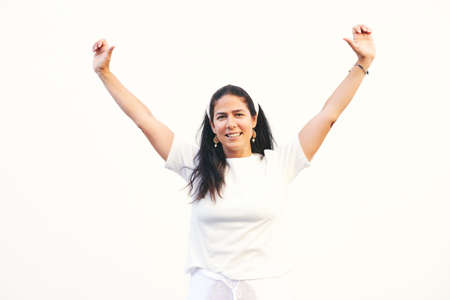 Portrait of happy middle age woman with raised handsの写真素材