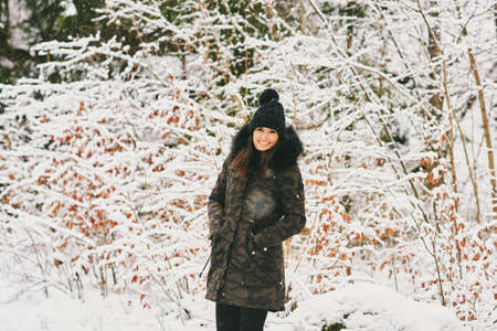 Seasonal outdoor portrait of happy young woman enjoying nice sunny day in winter forestの写真素材
