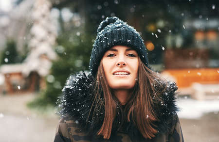 Seasonal outdoor portrait of happy young woman enjoying nice sunny winter dayの写真素材