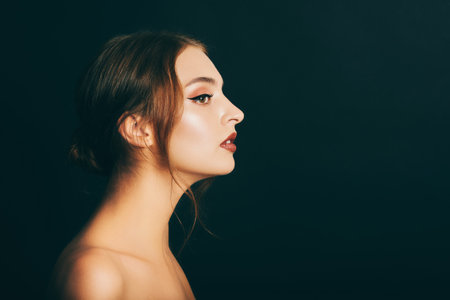 Close up portrait of beautiful young woman on black background, studio shot, profile imageの写真素材