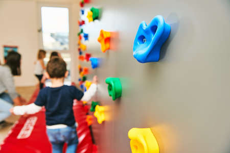 Wall with climbing grips in daycare or kindergarten, activity for little childrenの写真素材
