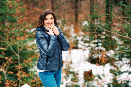 Early spring portrait of young happy woman enjoying nice day in forest