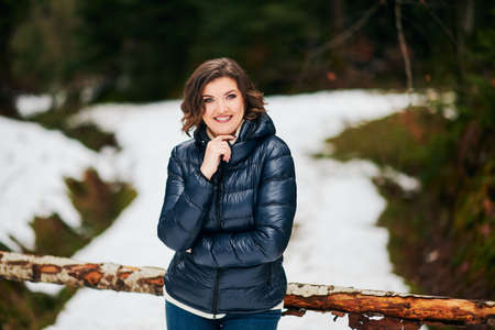 Early spring portrait of young happy woman enjoying nice day in forest