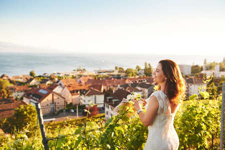 Woman enjoying nice view on Lake Geneva from Lavaux vineyards, Lausanne, Canton of Vaud, Switzerlandの写真素材