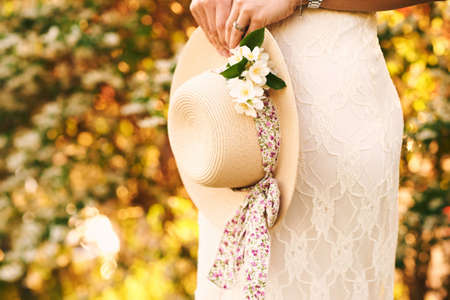 Spring garden, woman holding straw hat and jasmine branchの写真素材
