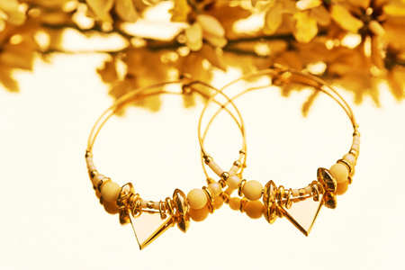 Close up image of handmade modern earrings on mirror background
