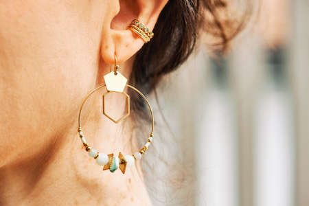Close up image of female ear wearing modern earringの写真素材