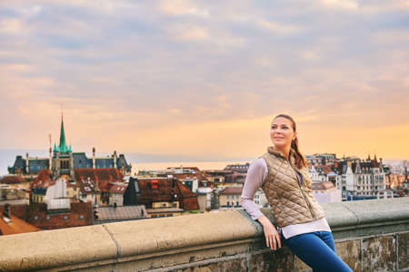 Outdoor portrait of beautiful young woman, european city landscape on background, Lausanne, Switzerlandの写真素材