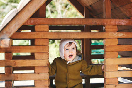 Outdoor portrait of cute toddler kid having fun on playground, wearing warm jumpsuitの写真素材