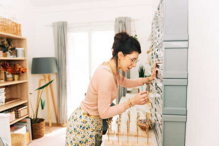 Jewelry designer working in studio, young woman creating handmade earringsの写真素材