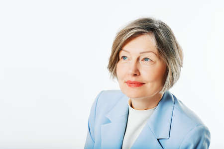 Studio portrait of middle age woman posing on white backgroundの写真素材