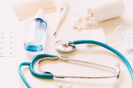 Medical background, stethoscope, digital thermometer, facial mask and pills on white backgroundの写真素材