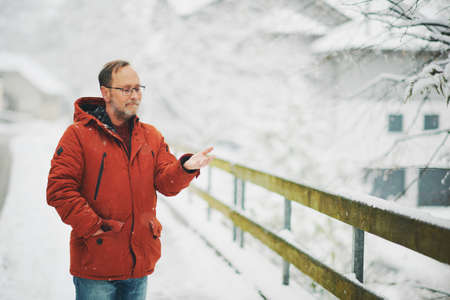 Outdoor portrait of middle age man, 55 - 60 years old, enjoying nice cold day, wearing red orange winter jacketの写真素材