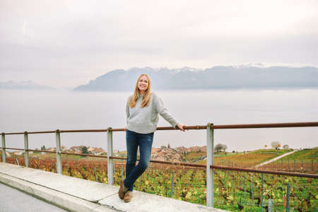 Outdoor portrait of beautiful young woman visiting Lavaux region in late autumn or early spring, canton of Vaud, Switzerlandの写真素材