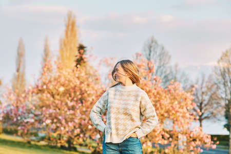 Outdoor portrait of young happy blond woman in spring park, emotional female model having fun on sunny warm dayの写真素材
