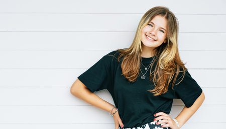 Outdoor portrait of pretty young teenage gir with brown hair posing on white background, wearing...