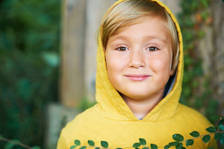 Outdoor portrait of adorable 5 year old boy wearing yellow hoodieの写真素材