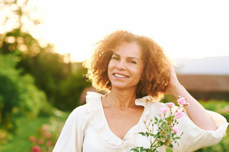 Outdoor close up portrait of beautiful middle age woman at sunsetの写真素材