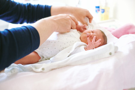 Father preparing newborn baby for the first bath