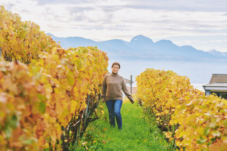Outdoor portrait of happy laughing woman hiking in autumn vineyards, Lavaux, Switzerlandの写真素材