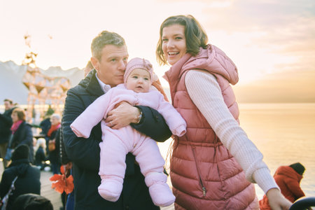 Outdoor portrait of happy family with adorable baby girl at Christmas marketの写真素材