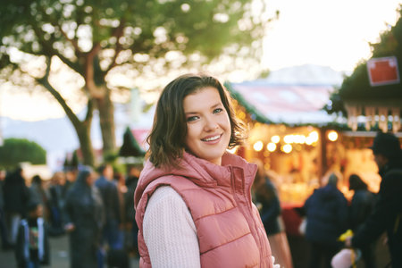 Outdoor portrait of happy young woman visiting Christmas marketの写真素材