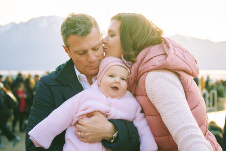 Outdoor portrait of happy family with adorable baby girl at Christmas marketの写真素材