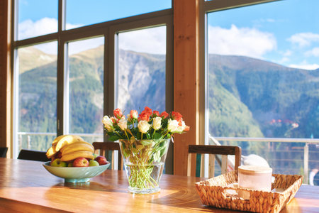 Dining table with colorful roses and banana bowl, mountain resortの写真素材