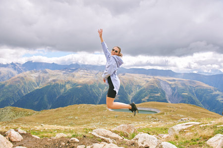 Outdoor portrait of happy young woman hiking in autumn mountains