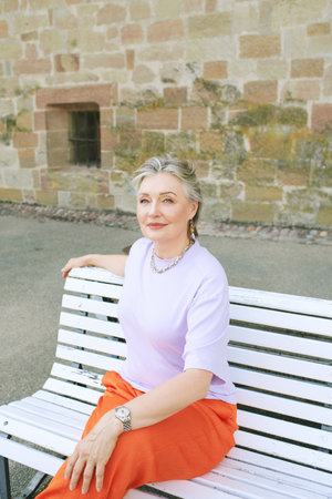 Outdoor portrait of mature happy woman relaxing on a benchの写真素材