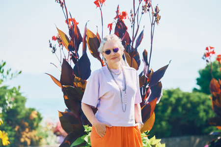 Outdoor summer portrait of happy and healthy mature 50 - 55 year old woman enjoying nice sunny day by the lake or sea, active lifestyleの写真素材