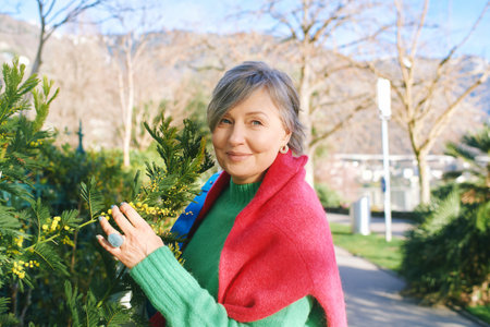 Outdoor portrait of beautiful mature 55 - 60 year old woman, wearing warm sweaterの写真素材