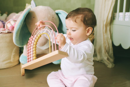 Portrait of adorable 9 months old baby girl playing at home with educational toysの写真素材