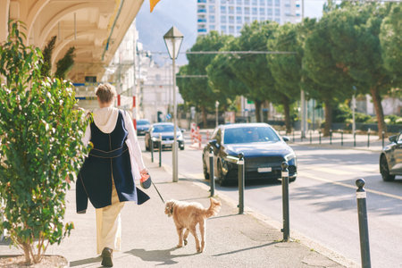 Outdoor portrait of happy mature woman walking with dogの写真素材