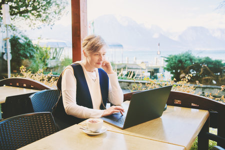 Outdoor portrait of mature 55 - 60 year old woman working with laptopの写真素材