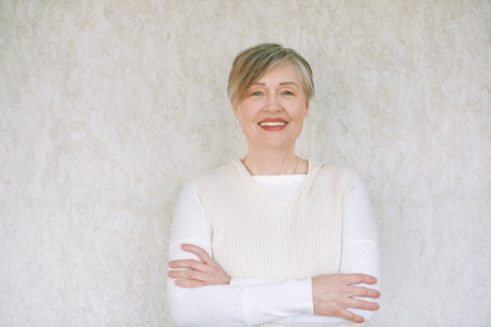 Portrait of mature 55 - 60 year old woman with gray hair, arms crossedの写真素材