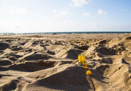 Amber in the sand against the background of sea waves and skyの写真素材