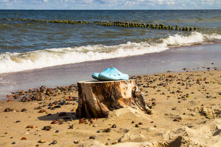 Pair of blue flip flops, sandal on beach. Summer time vacation attribute, slippers, shoes...