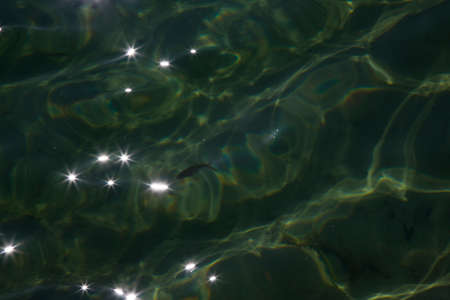 Glare of sunlight on the water. Background, texture of water and lightの写真素材