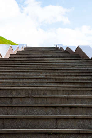 Concept photo of a staircase in a bright cloudy sky, side view. A large stone staircase leads to the sky. Natural sceneryの写真素材