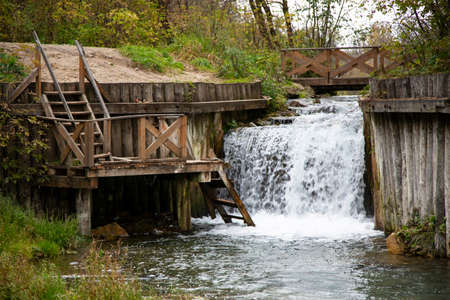 Small waterfall and small clear pond, inside the forest, autumnの写真素材