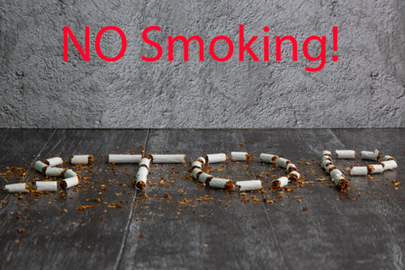 The word stop is written using cigarettes on a dark background. Concept: harm of Smoking, stop Smokingの写真素材